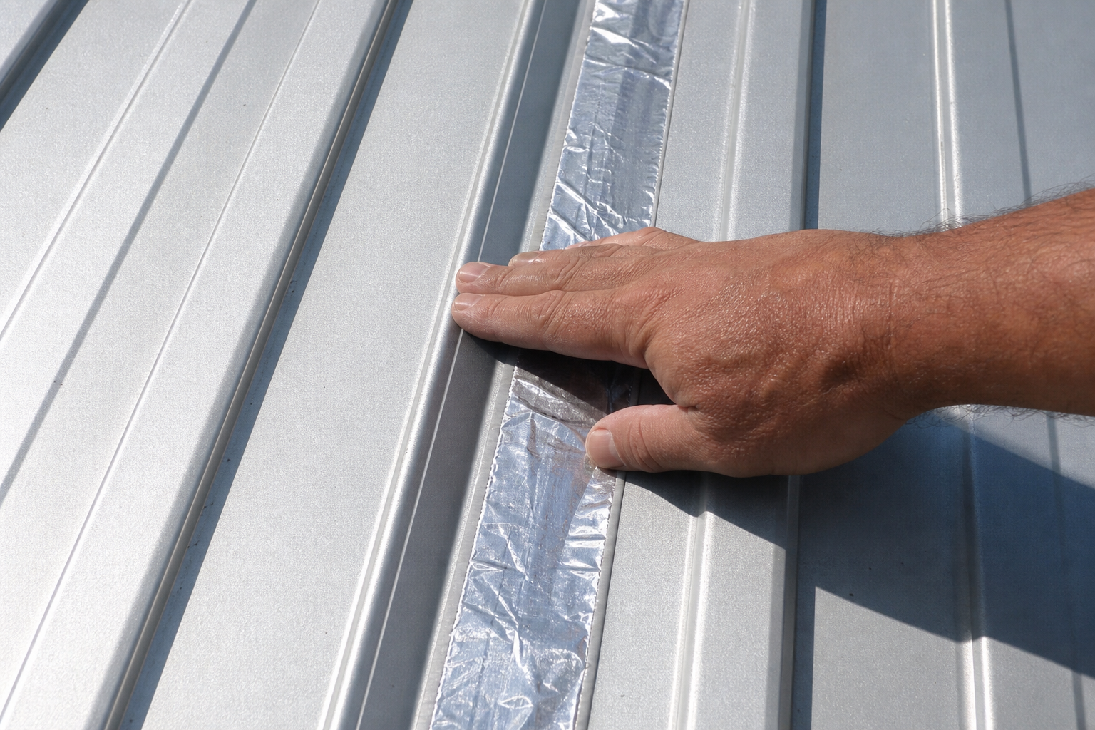 Butyl tape strip on a corrugated metal roof seam